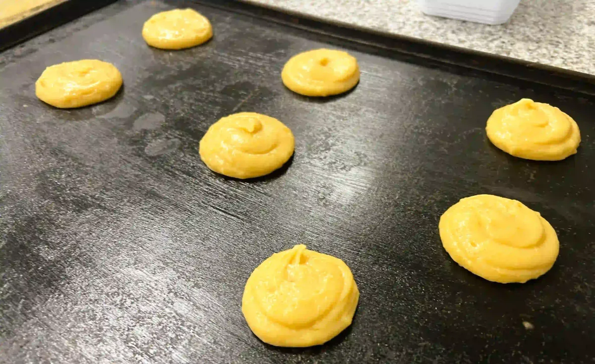 Choux buns piped onto a baking tray