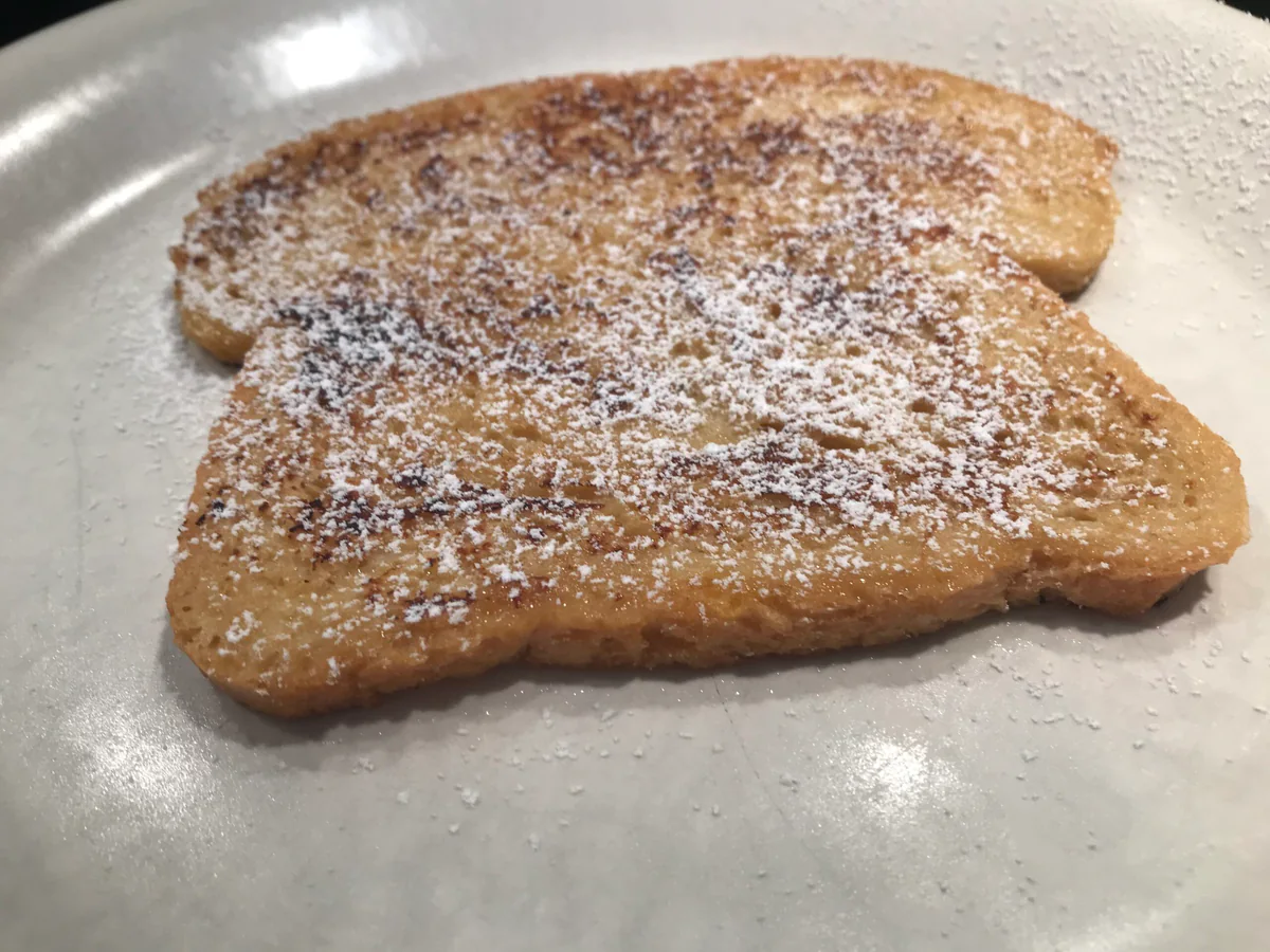 French toast dusted with icing sugar on a plate.
