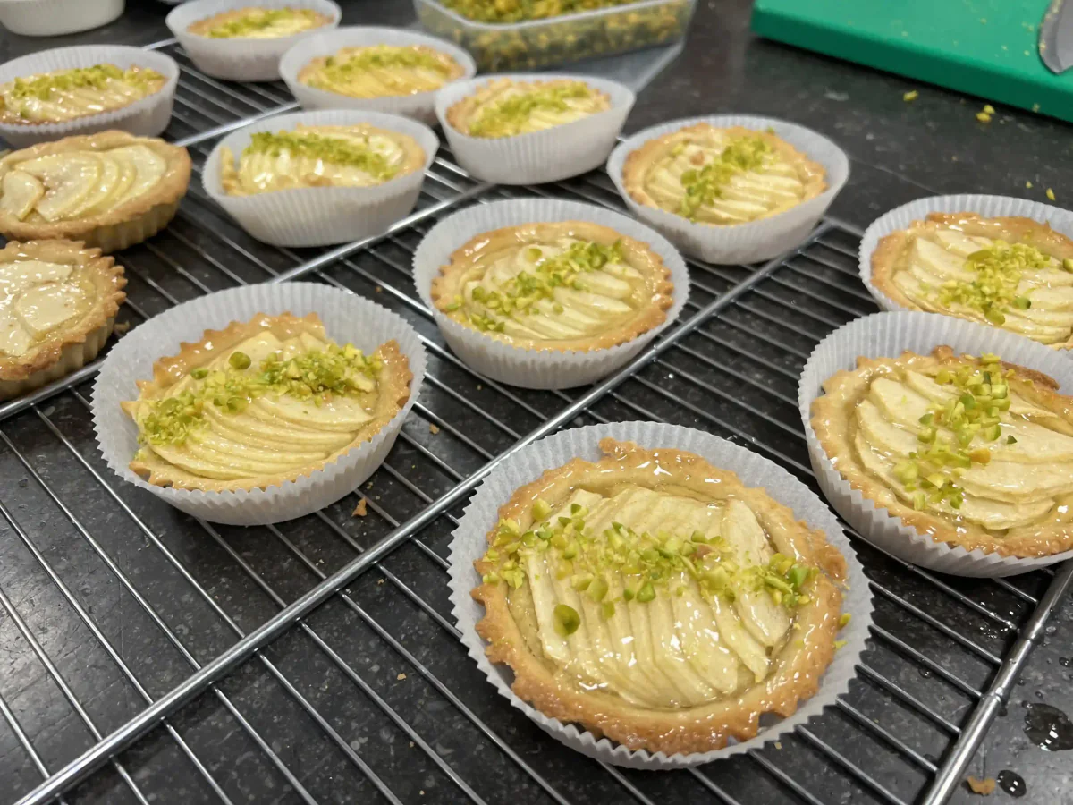 Kleine Apfeltartes auf einem Gitter.