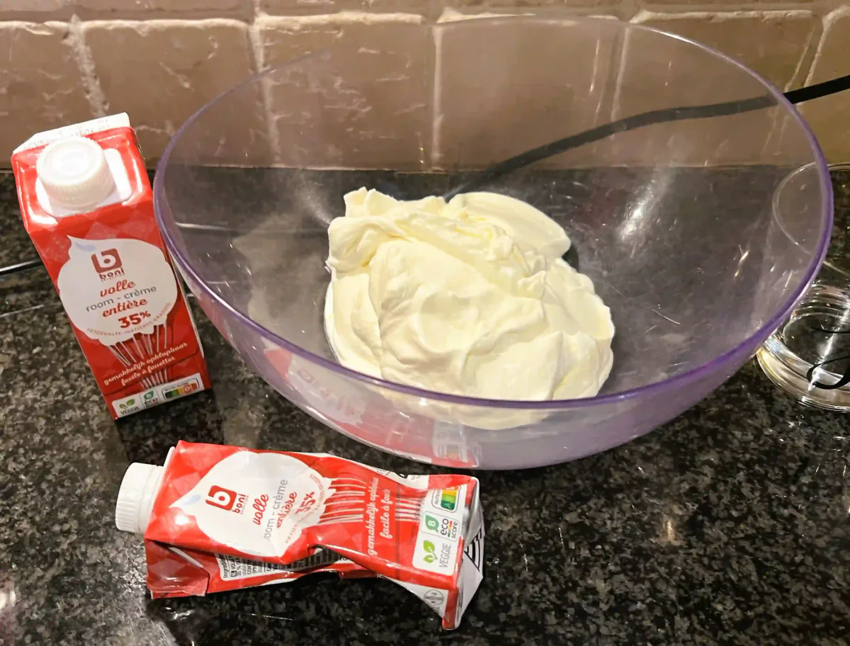 Schlagsahne und Sahnepackungen in einer Rührschüssel.