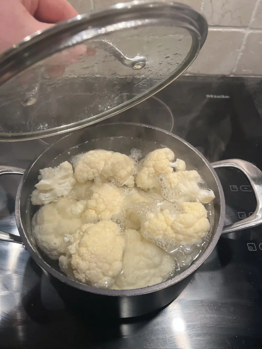 Floretes de coliflor cocinándose en una olla.