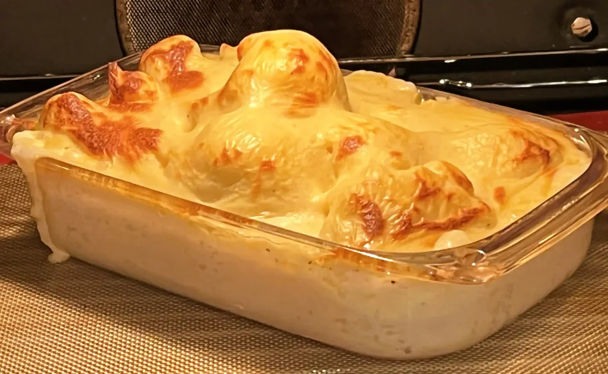Coliflor gratinada en salsa blanca con una costra dorada.
