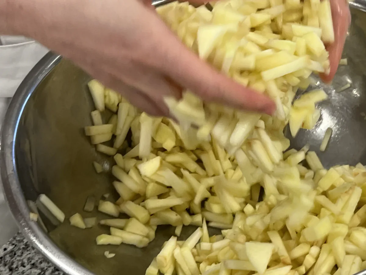 Geschnittene Äpfel in einer Schüssel sammeln.