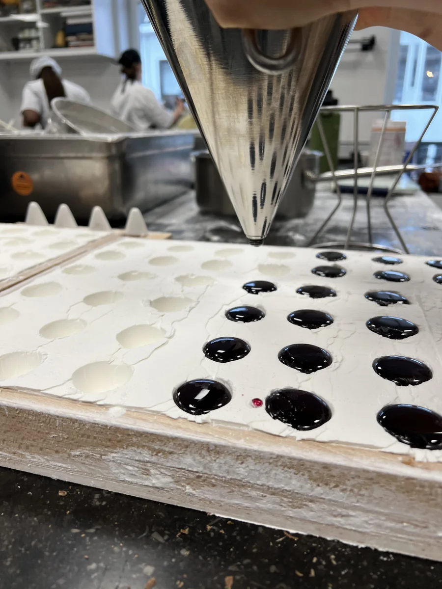 Pouring cuberdons into a starch tray