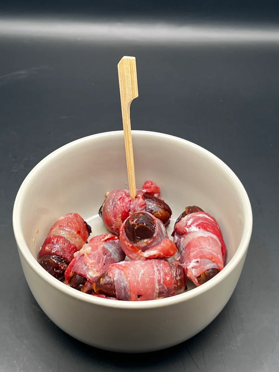 Dates wrapped in bacon with honey, baked until crisp