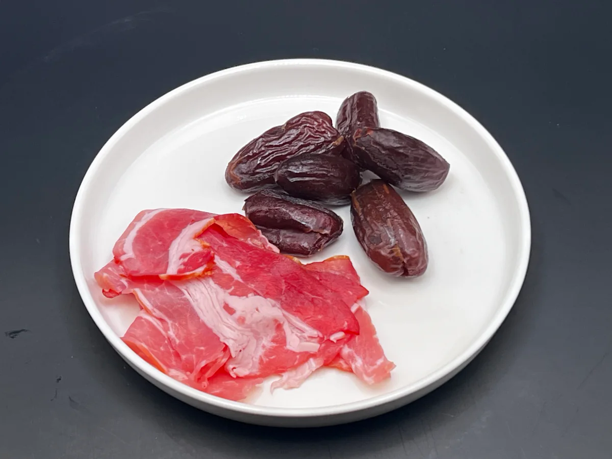 Dates with bacon: ingredients on a plate