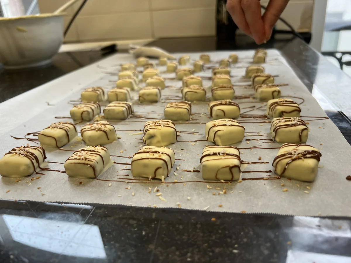 White dipped chocolates drizzled with dark chocolate and finished with desiccated coconut