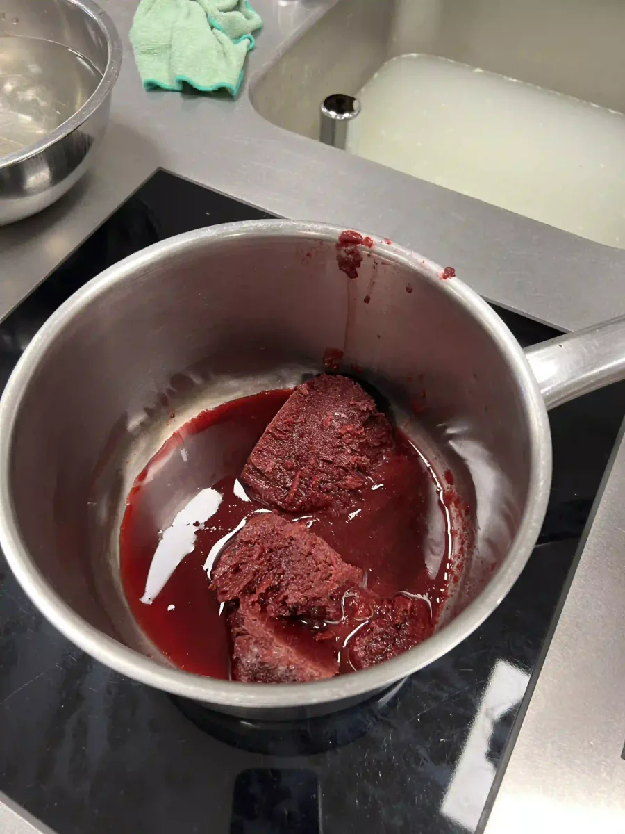 Rode fruitpuree in een kookpot.