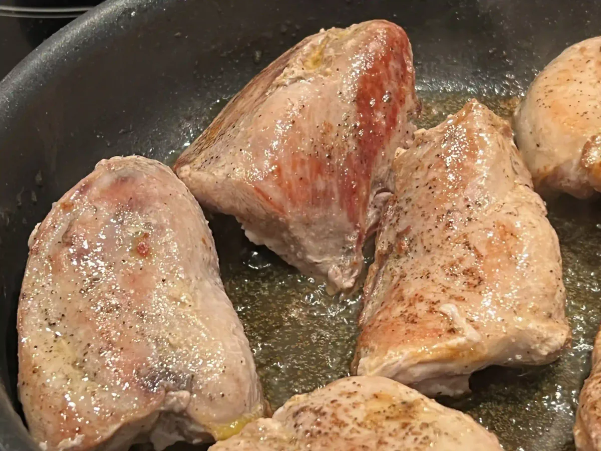 Browning pieces of meat in a pan.