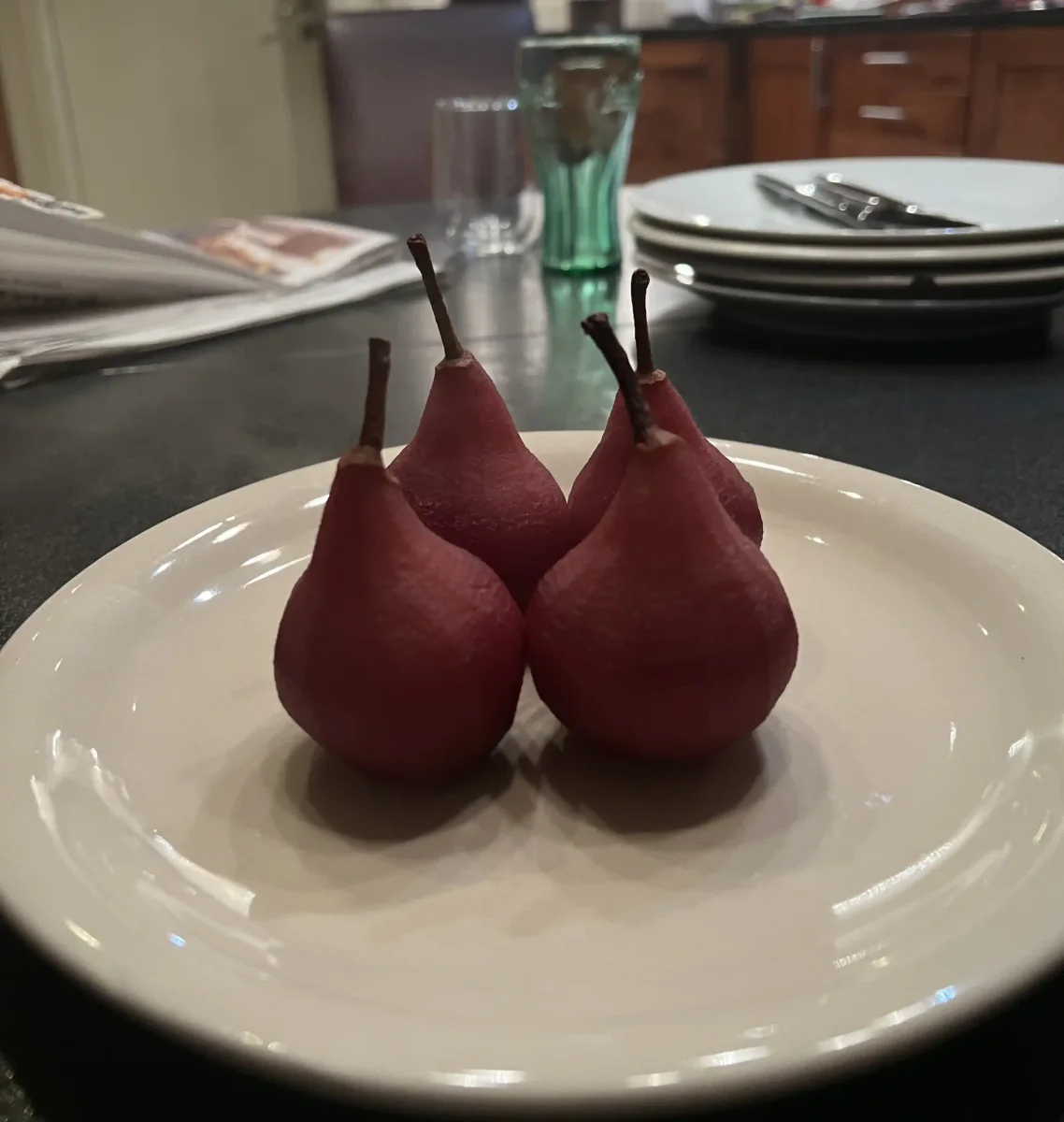Pears poached in red wine on a plate.