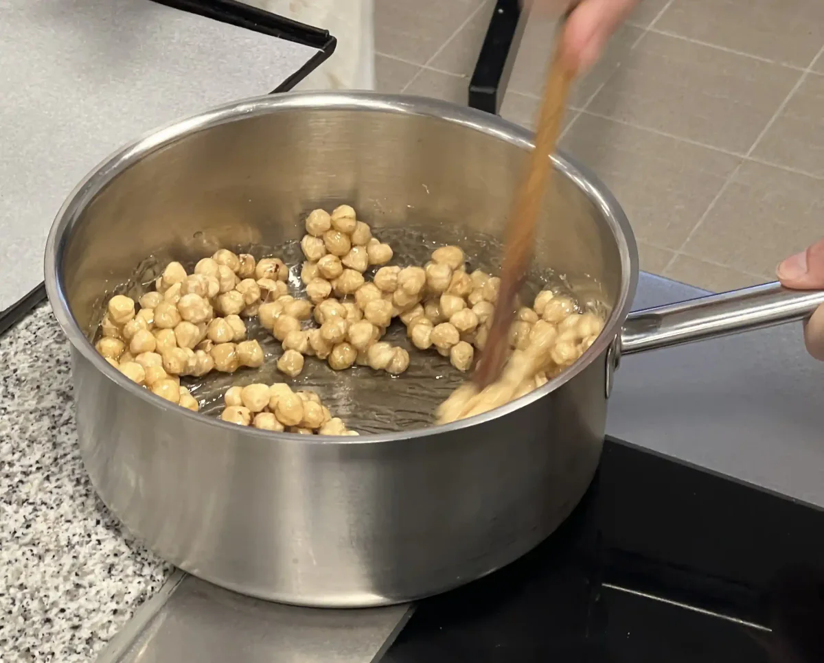Haselnüsse unter den Zuckersirup rühren.