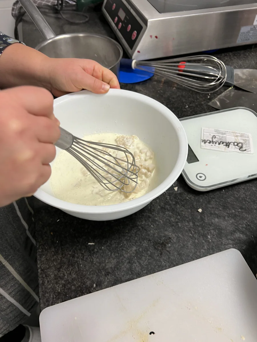 Ganache mit einem Schneebesen in einer Schüssel verrühren.