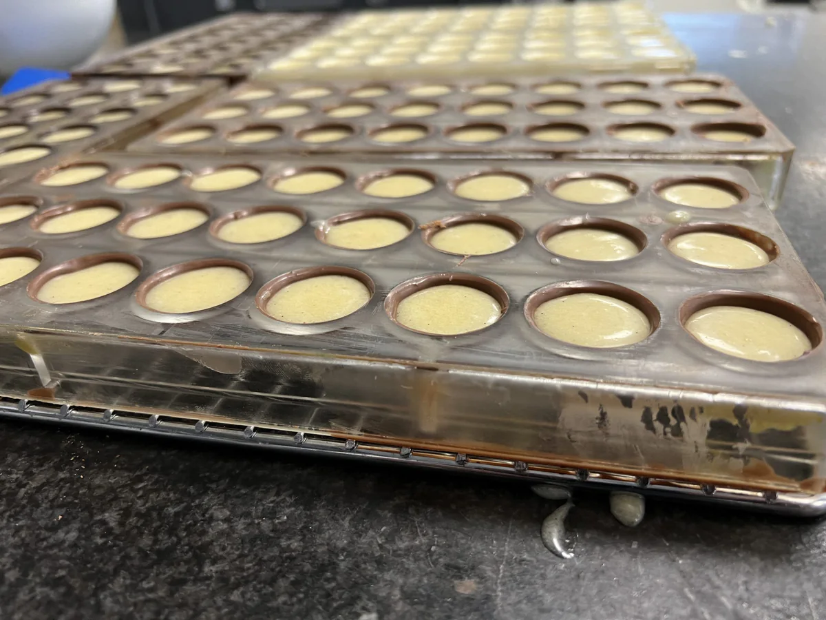 Pralinenformen mit gefüllten runden Vertiefungen.