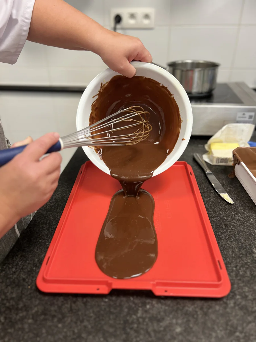 Pouring the chocolate mixture onto a silicone mat.