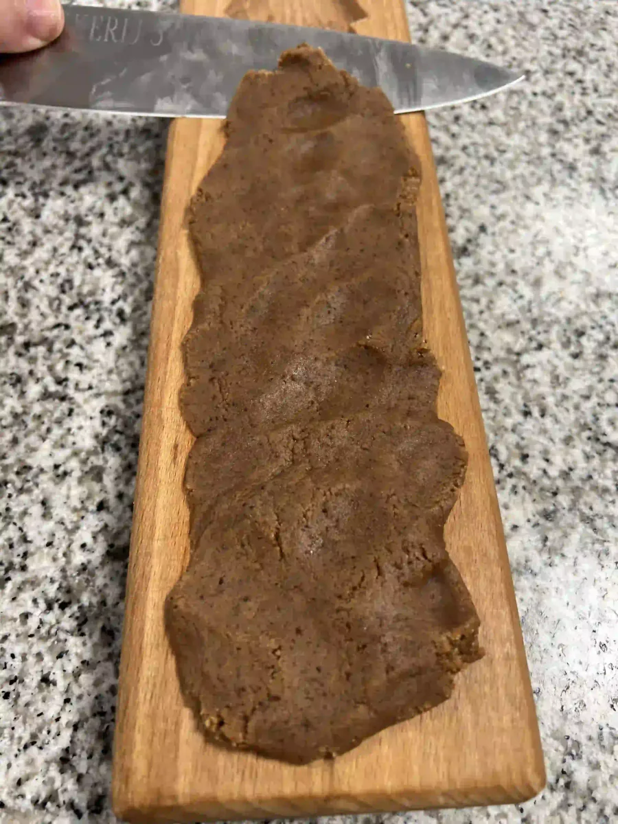 Araser la pâte à spéculoos dans le moule en bois.