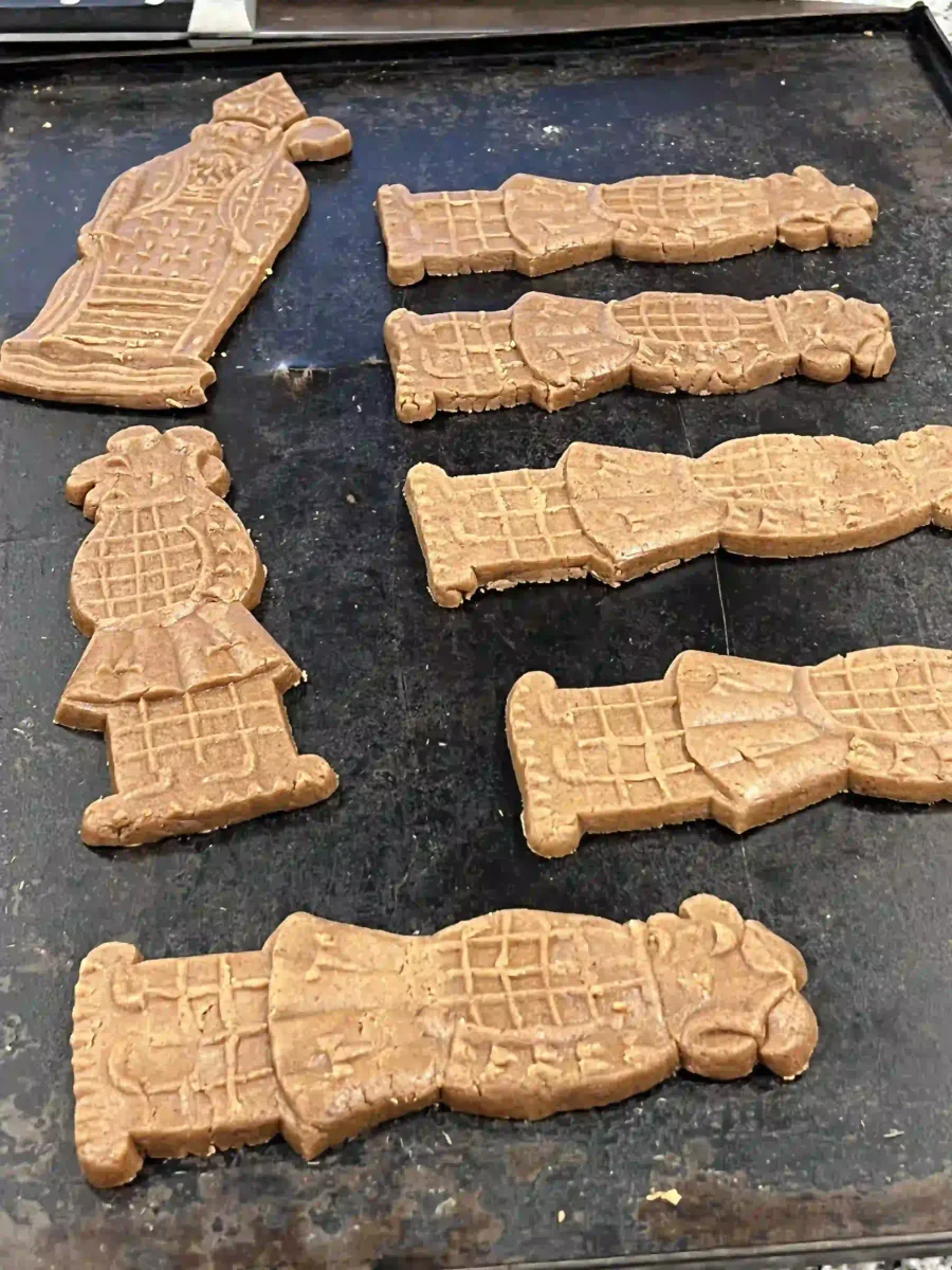 Figurines de spéculoos démoulées sur une plaque de cuisson.