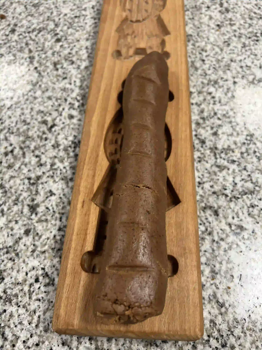 Presser la pâte à spéculoos dans un moule en bois.