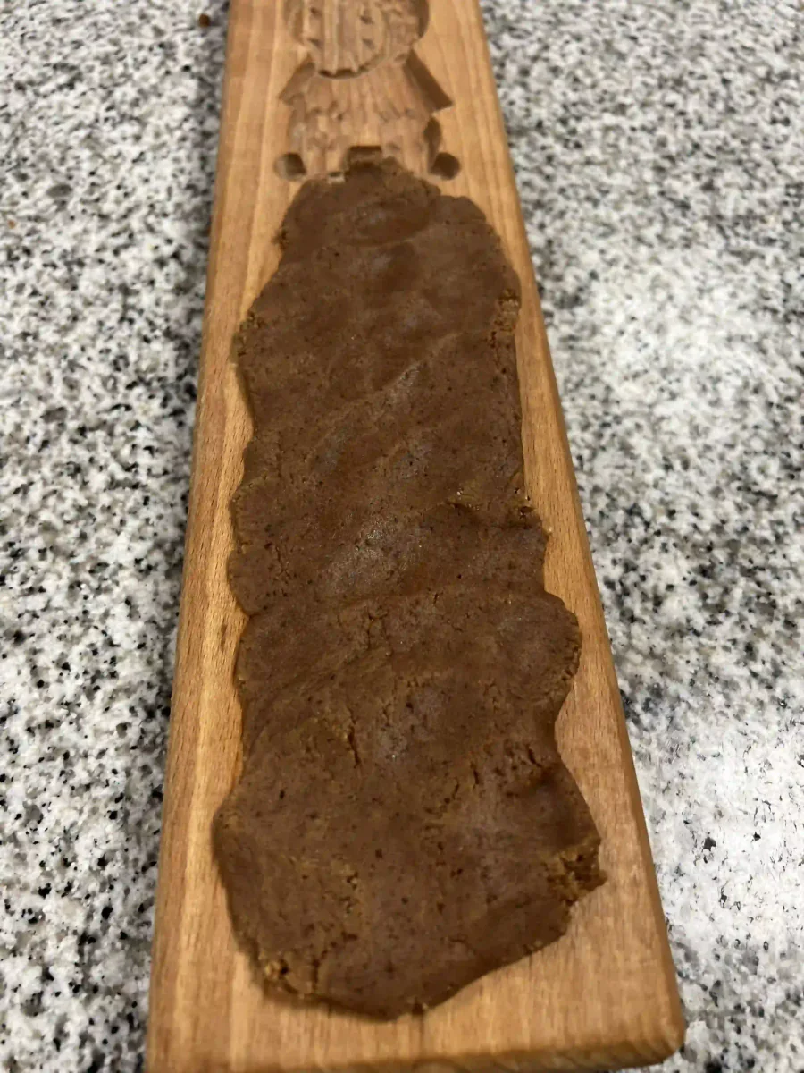 Répartir la pâte à spéculoos sur le moule en bois.