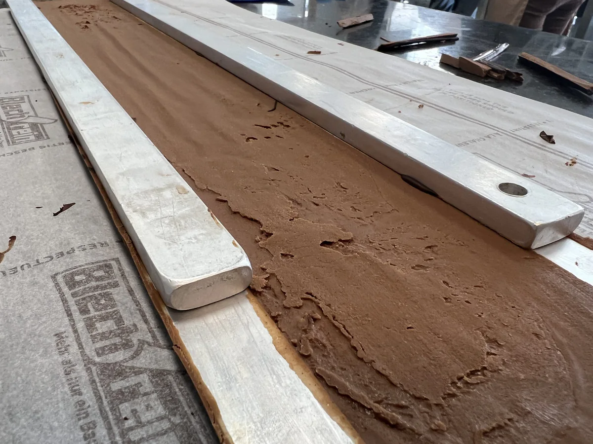 Rectangular layer of chocolate cream on the worktop.