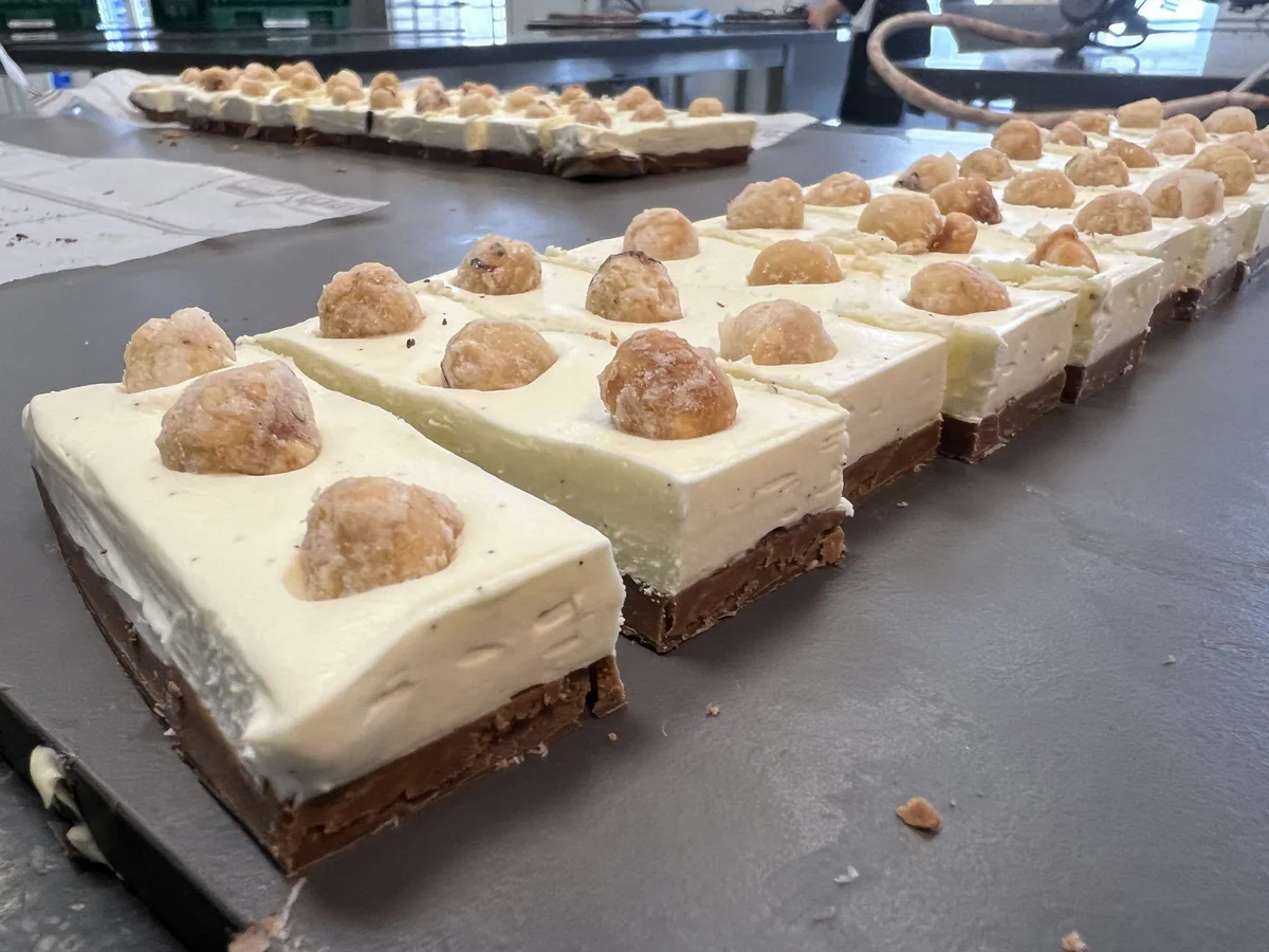 Rectangular pastries finished with cream and a biscuit.