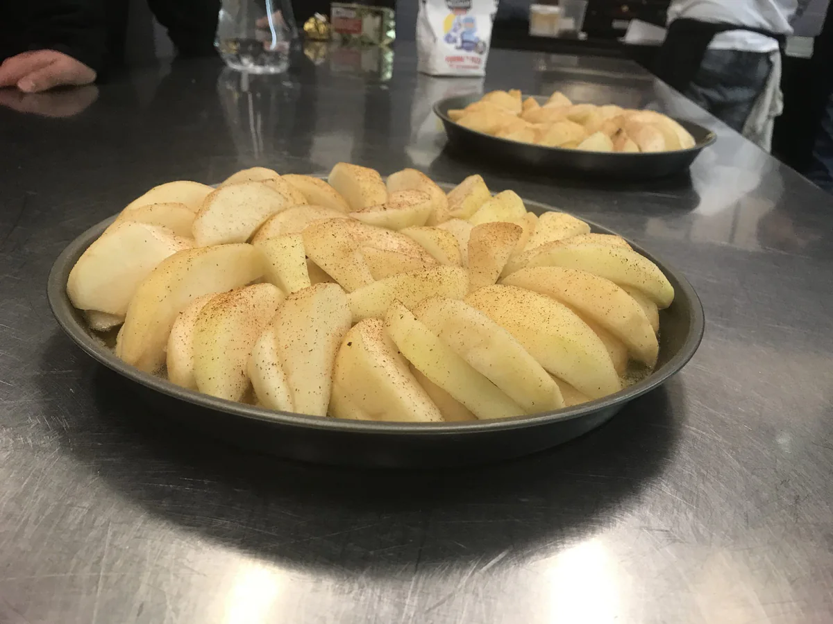 Plakjes peer in een ronde bakvorm voor tarte tatin.