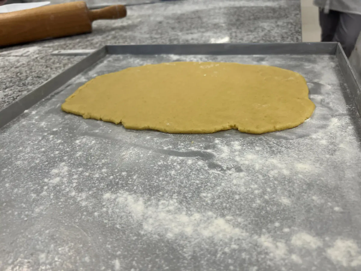 Rolling out dough on a floured worktop.