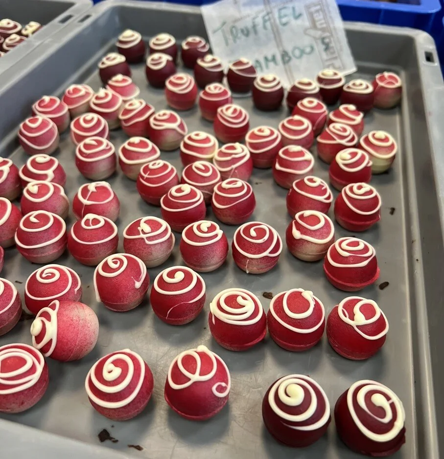 Raspberry truffle finished with a red coating and a white chocolate spiral