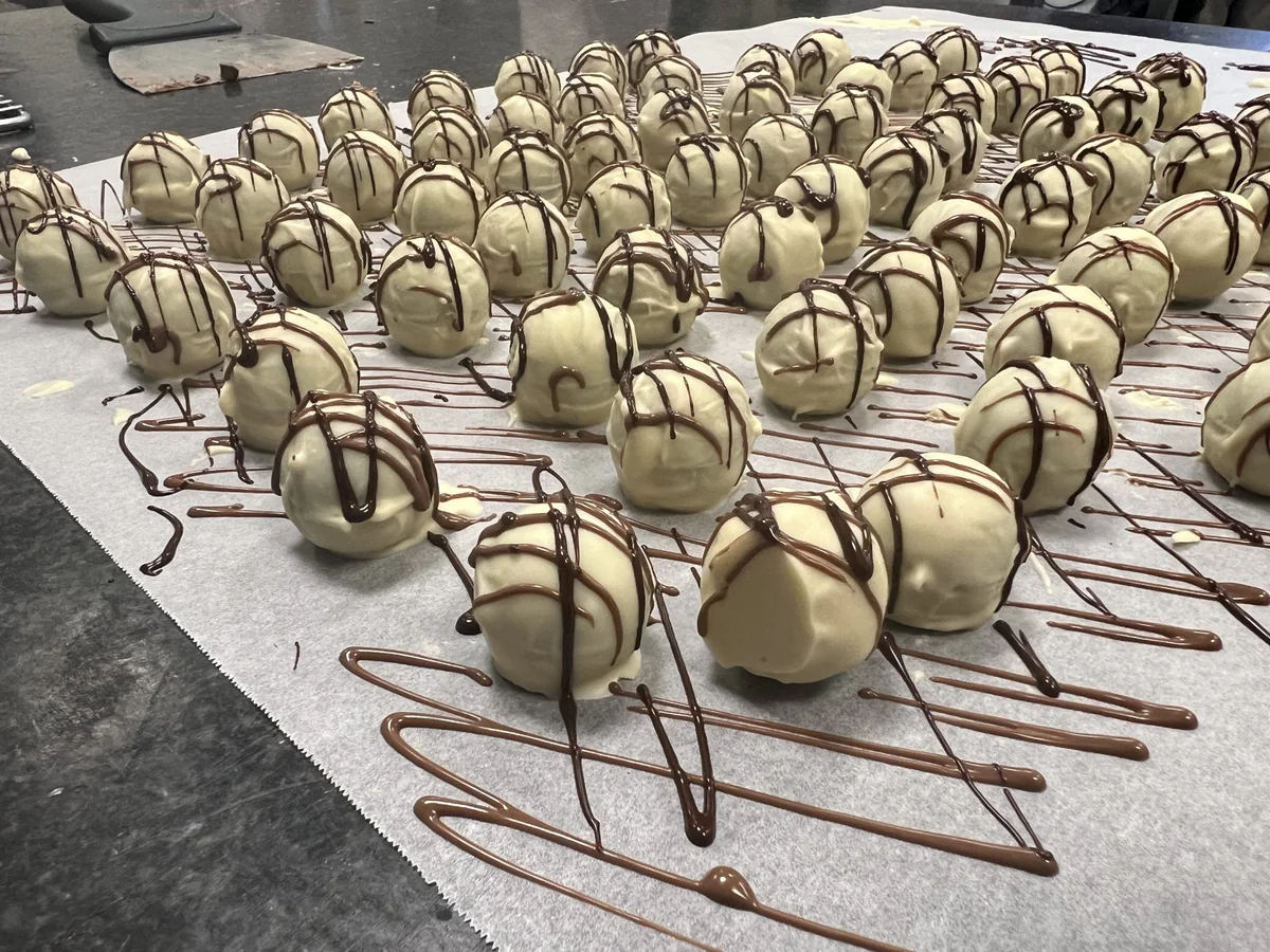 Weiße Schokoladenkugeln mit dunklen Schokoladenstreifen.