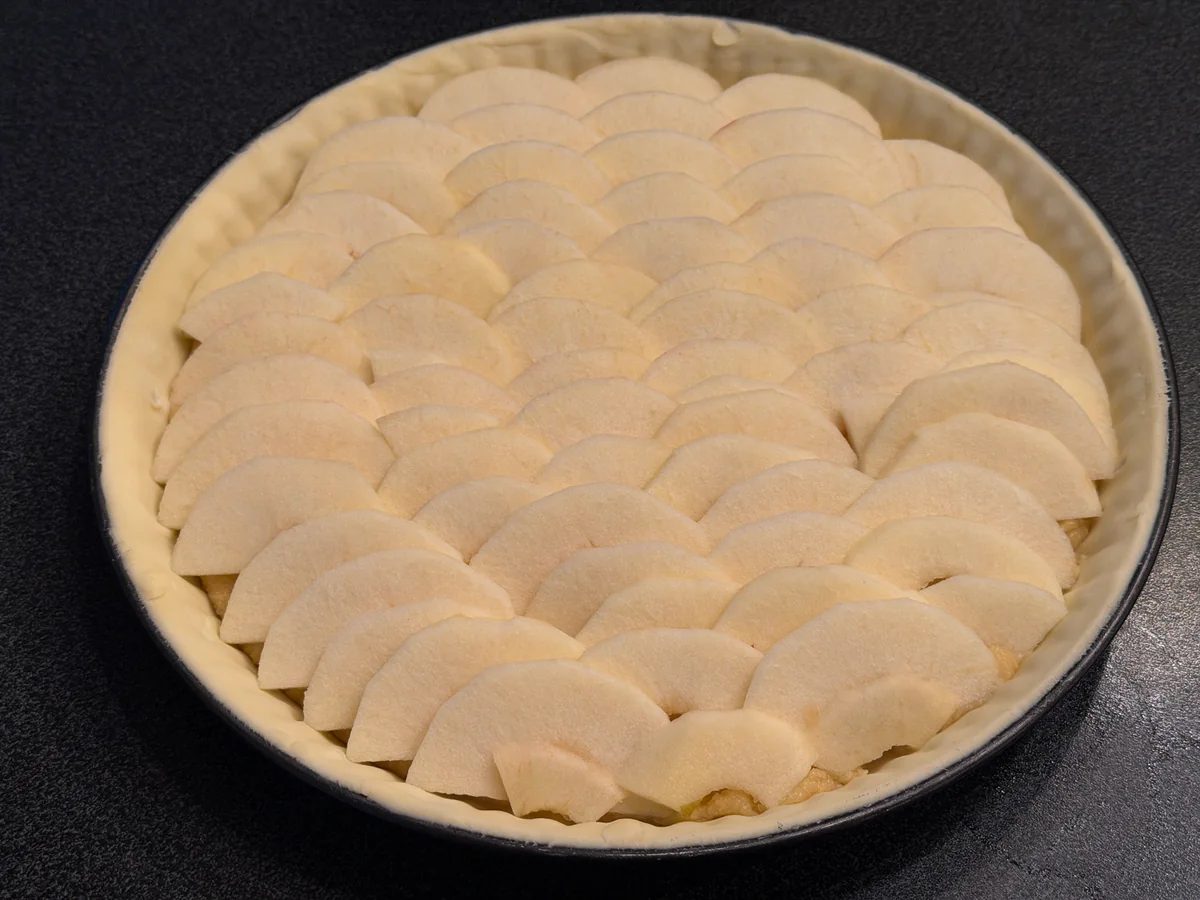Dunne geschilde appelschijfjes overlappen op de frangipane