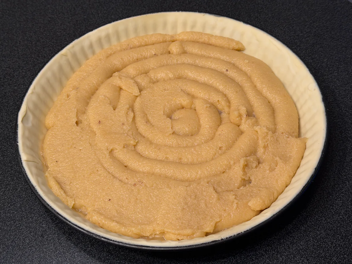 Frangipane in een spiraal op de taartbodem gespoten