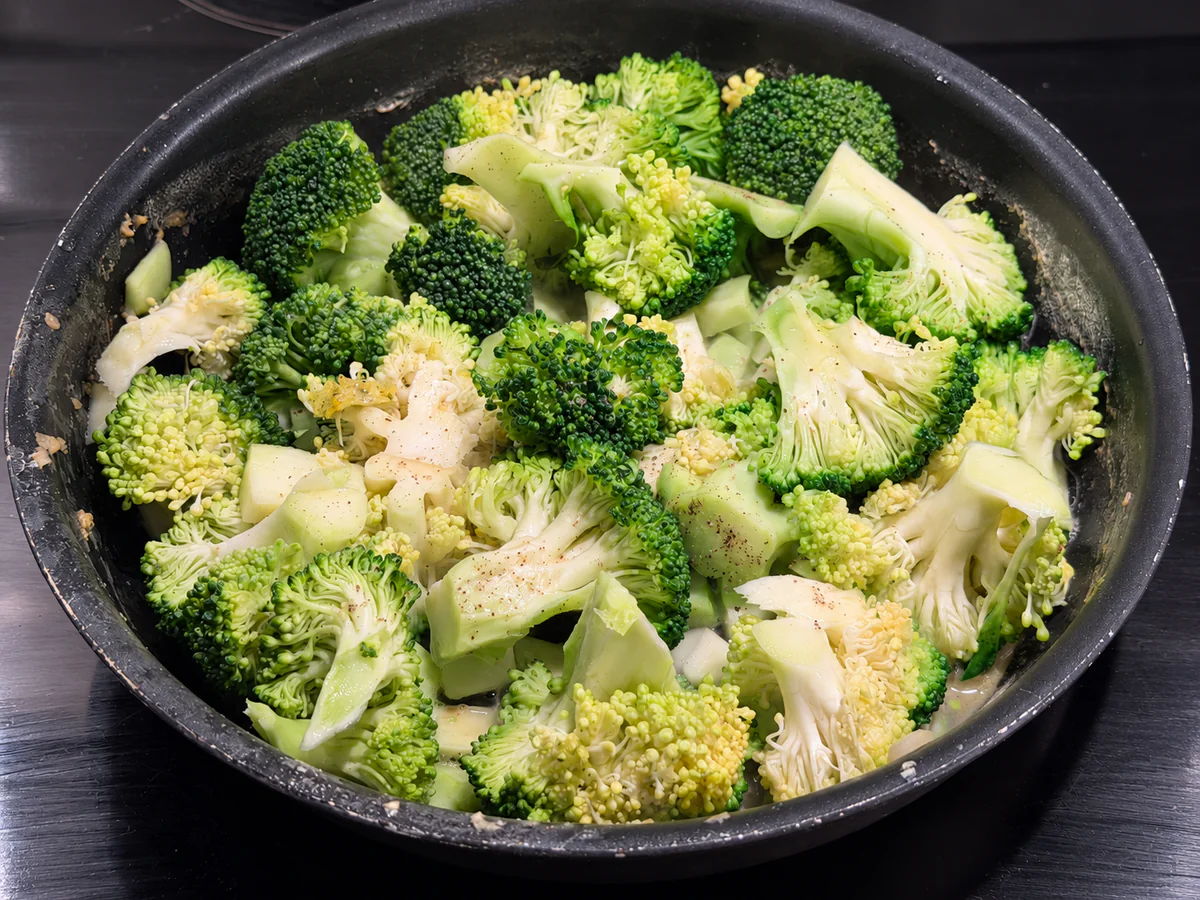 Broccoliroosjes en stukjes stronk garen in een braadpan
