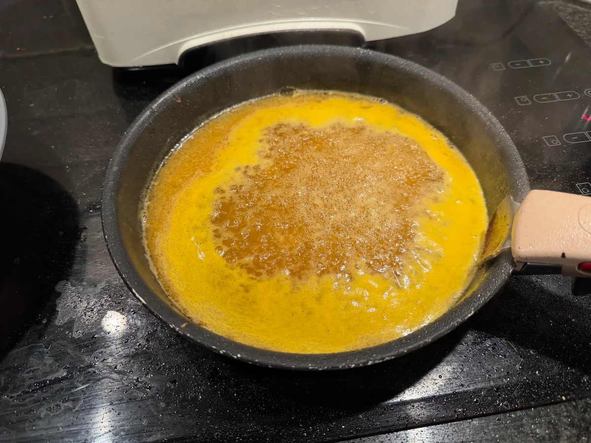 Appelsiensaus die inkookt in de braadpan.