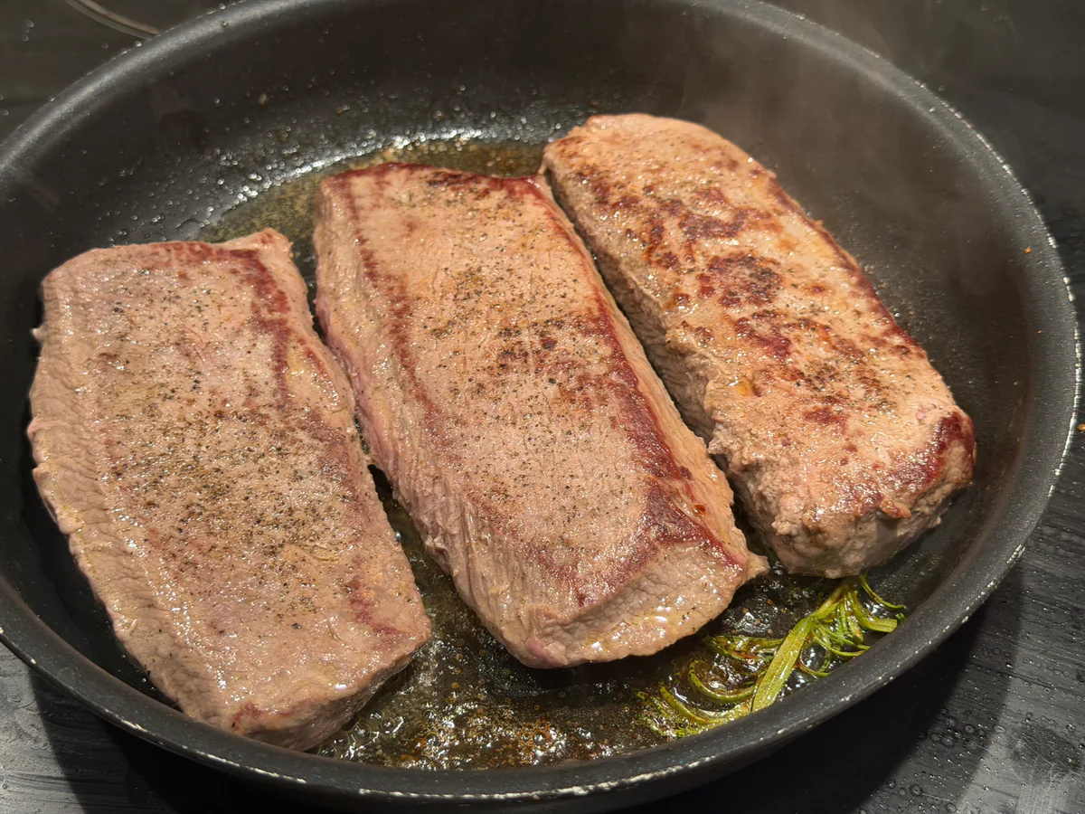 Lamsfilet met een bruin gebakken korst in de braadpan