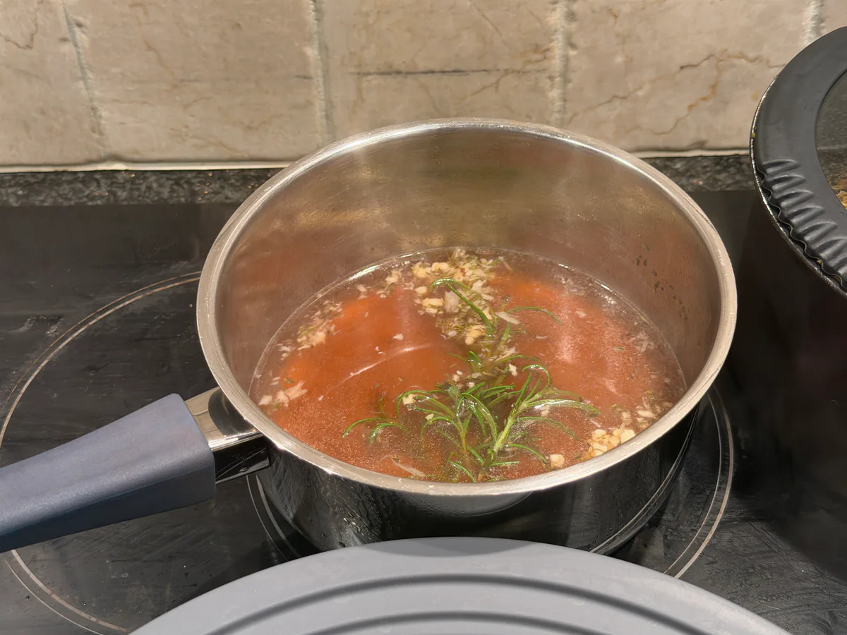 Wildbouillon met rozemarijn, tijm en geplette look in een steelpan