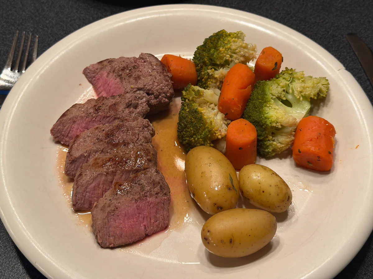 Lamsfilet in plakken met wildjus, krieltjes, geglaceerde wortelen en broccoli