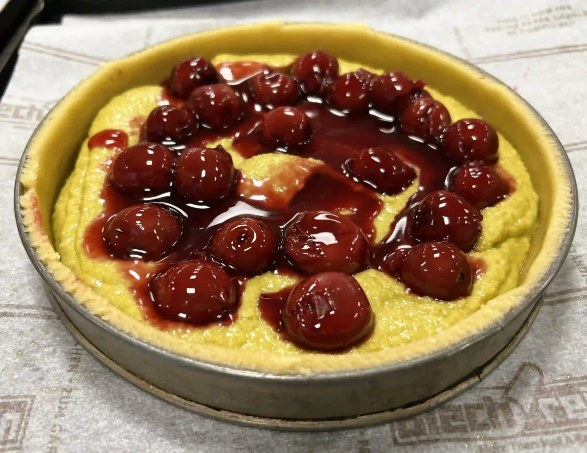 A tart base with cream and sour cherries.