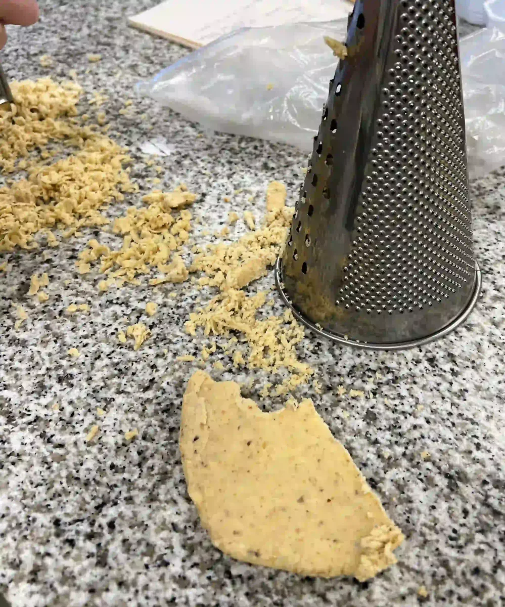 Grating dough into crumbs on the work surface.