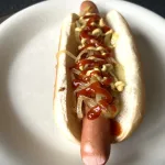 Hotdog met ajuin ketchup en mosterd