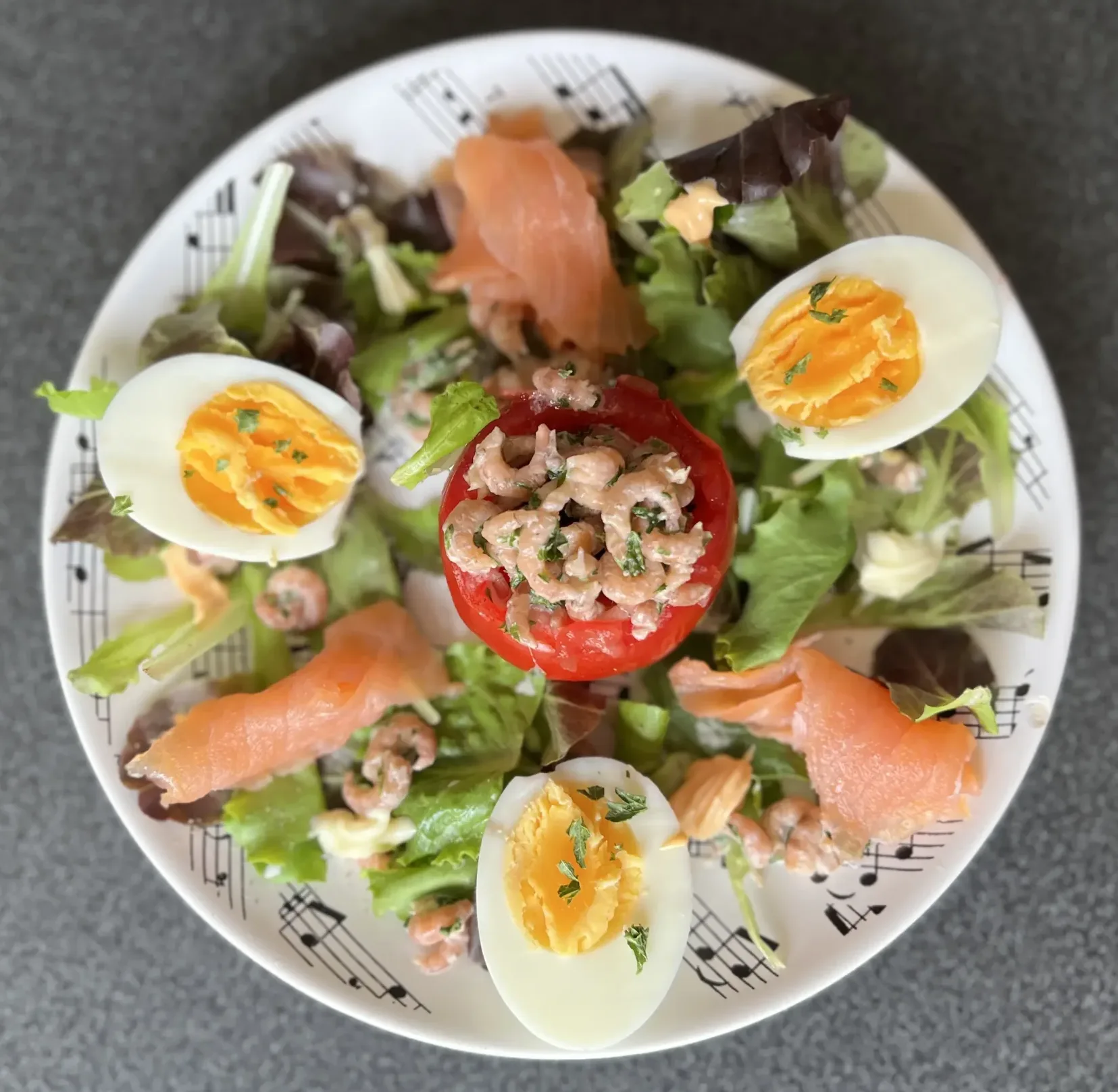 Tomaat garnaal op een bedje van sla afgwerkt met zalm en ei