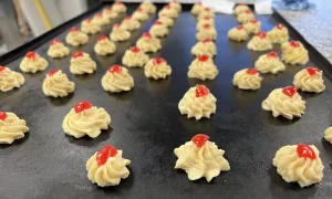 Gespoten boterbloemkoekjes of margrietjes met stukje fruit