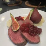 Hertengebraad op een bedje van knolselderpuree met gestoofd peer in rode wijn siroop met een veenbessencompote saus