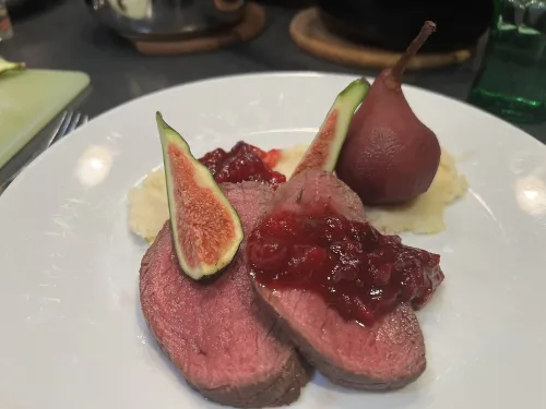 Hertengebraad op een bedje van knolselderpuree met gestoofd peer in rode wijn siroop met een veenbessencompote saus