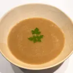 Kom warme champignonsoep met miso, afgewerkt met peterselie
