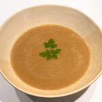 Kom warme champignonsoep met miso, afgewerkt met peterselie