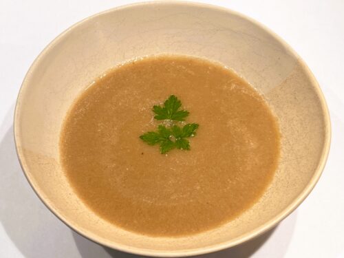 Kom warme champignonsoep met miso, afgewerkt met peterselie