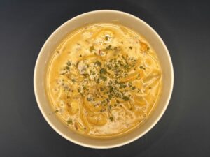 Bovenzicht van champignonroomsaus met witte wijn en room, afgewerkt met oregano