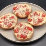 Vier halve pistolets belegd met tomaat, hesp en gesmolten mozzarella — pistolet pizza’s vers uit de oven